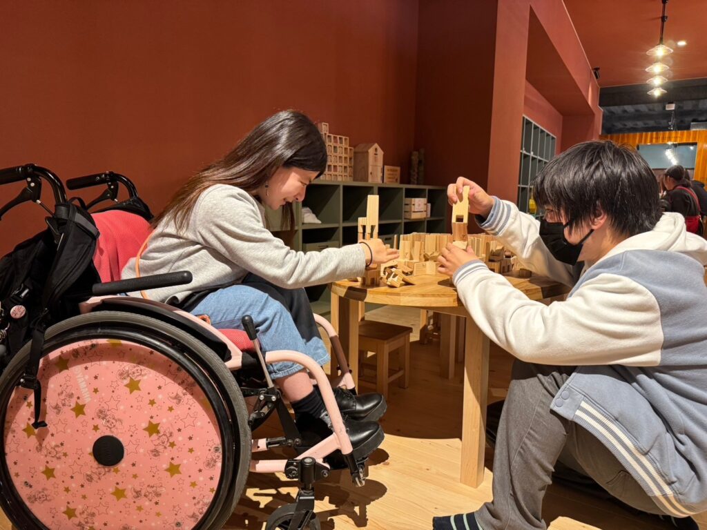 讃岐おもちゃ美術館で木製おもちゃで遊びながら学んでいる学生たちの楽しげな表情